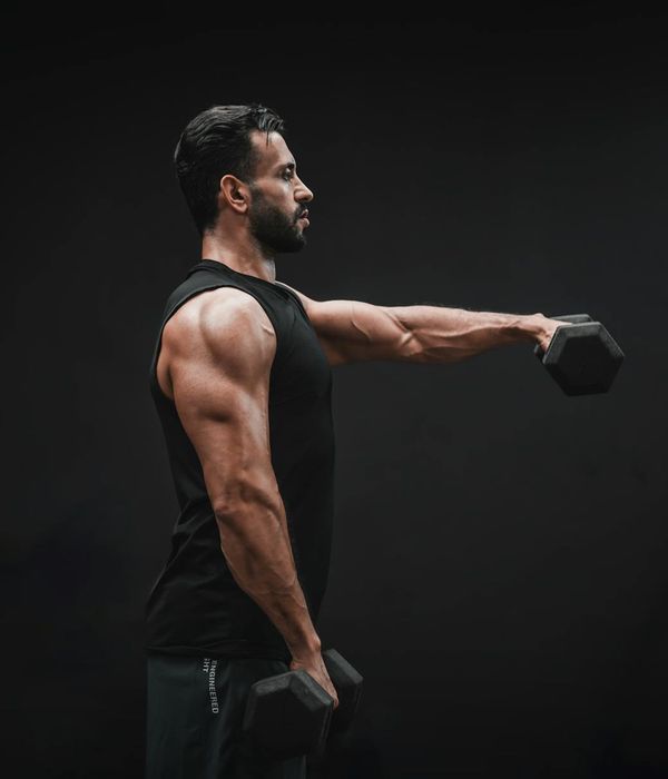 A man in athletic wear concentrating before a workout, seen from the side.