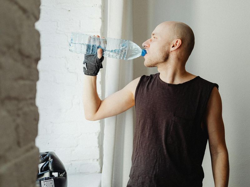 Man performing a controlled bodyweight exercise in a minimalist gym setting.